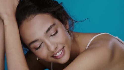 Beautiful Woman Posing in Front of a Blue Background