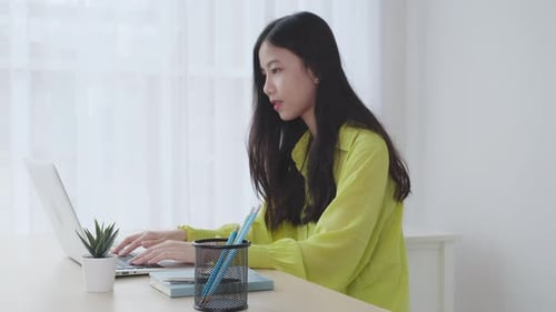 Young asian businesswoman working on laptop computer on desk at home office.