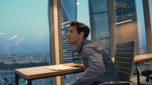 Excited Young Adult Celebrating Success in Modern Office