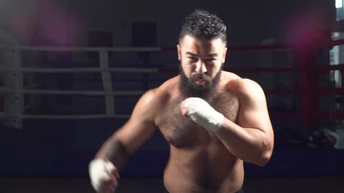 Muscular Man Boxing in a Ring