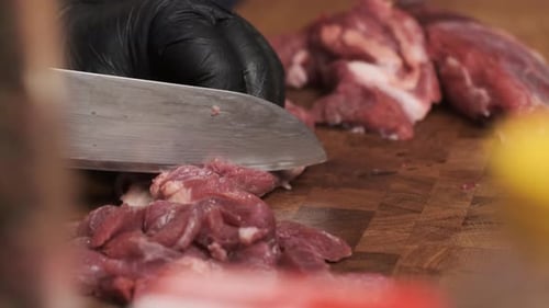 Close Up Footage Chef in Restaurant Kitchen Cuts Red Meat or Lamb with Sharp Shiny Knife