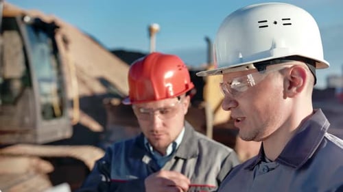 Construction Engineers Discussing Plans on Site