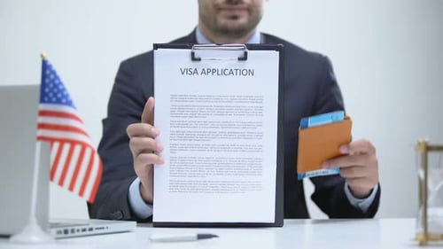 Man Holds Visa Application and Passport
