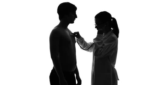 Doctor Examining Young Man with Stethoscope in Silhouette