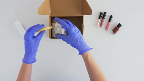Hands in Gloves Packing Parcel Box with Cosmetics