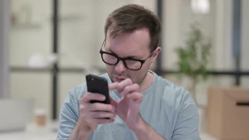 Man Using Smartphone in Office Close Up