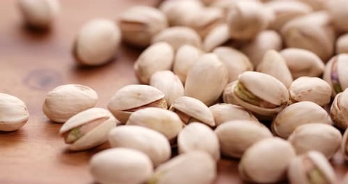 Close Up Footage of Falling Pistachios on Wood