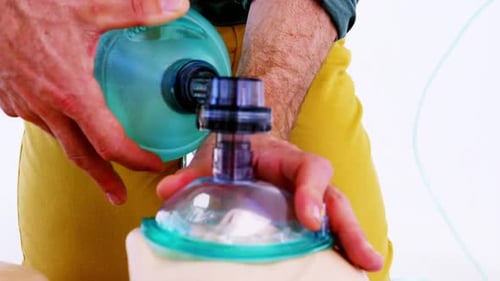 Medical Professional Using a Bag Valve Mask on Dummy