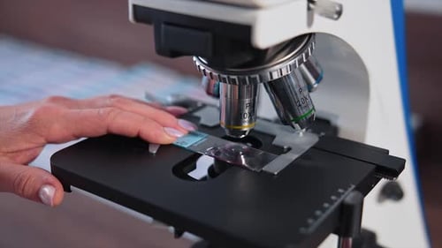 Scientific laboratory microscope examining drop. Close up shot of sample slide and microscope with m