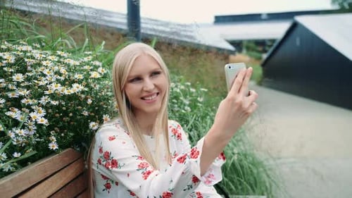 Woman Using Smartphone Outdoors on Bench