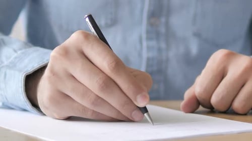 Hands Write on Paper with Pen Close Up