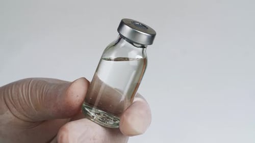 Close Up of Medicine Vial in Gloved Hand