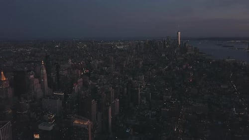 AERIAL: Manhattan Drone Flight at Night with Glowing City Light in New York City