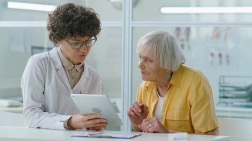 Doctor Explains Diagnosis to Senior Patient on Tablet
