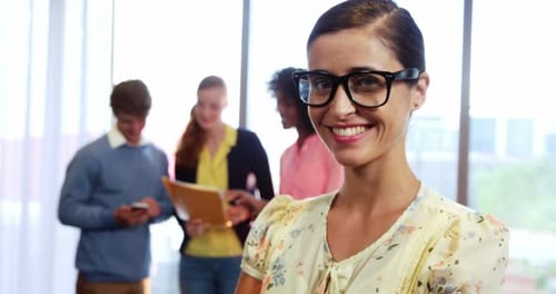 Smiling Woman in Office Workplace with Coworkers