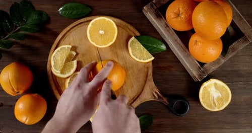 Hände Mann mit einem Messer reife Orange in zwei Hälften schneiden.