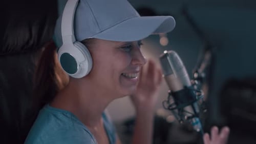 Beautiful Woman In A Cap And White Headphones Leads A Live Stream