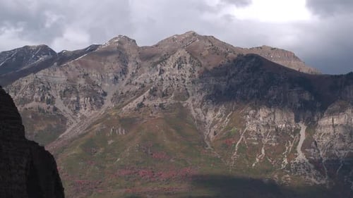 Aerial pan viewing mountain as cliff appears in front