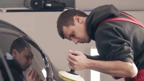 Car Polisher Buffing Vehicle's Surface in Bright Garage