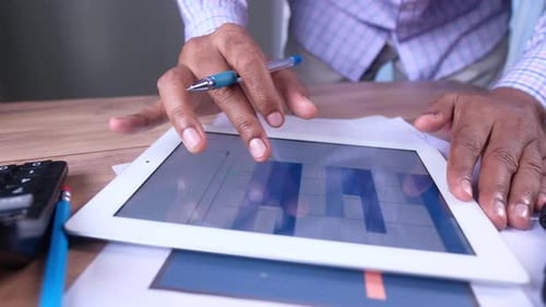 Man's Hand Working on Digital Tablet at Office Desk, Using Self Created Chart