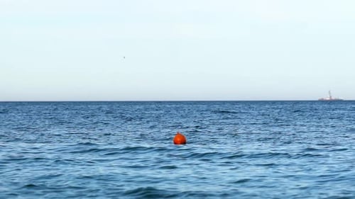 Navigational buoy in sea. Orange buoy floating in sea water