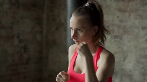 Woman Boxer Training Indoors with Punches