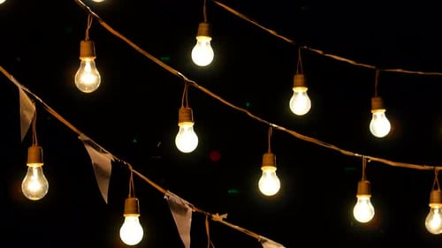 Light bulbs garland hanging in the air, Tilt down shot.