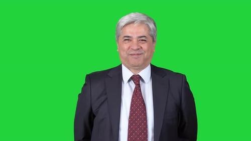 Man in suit looking at camera and laughing.