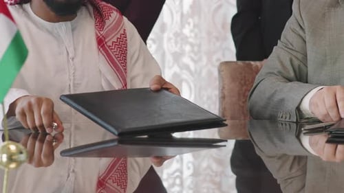 Businessmen Signing Documents and Shaking Hands in Office