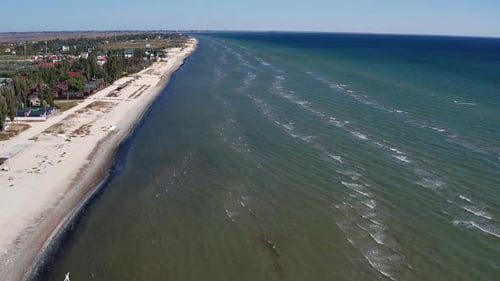 Beautiful flight in summer over the beach. People are resting near the sea. Houses for tourists.