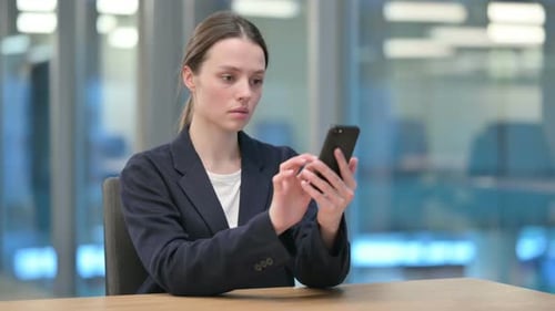 Young Woman Using Smartphone in Modern Office