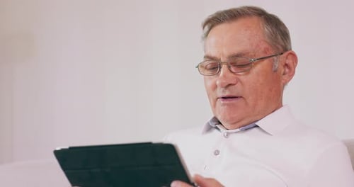 Senior Man Reading Tablet at Home, Close Up
