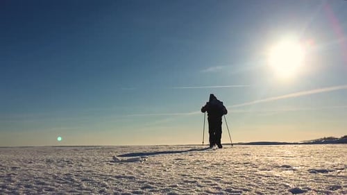 Hiker Walking Across Snow in Winter Landscape