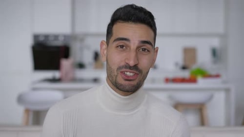 Smiling Man Waving in a Modern Kitchen