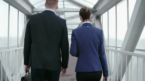 Business People Walking Together Along Elevated Walkway