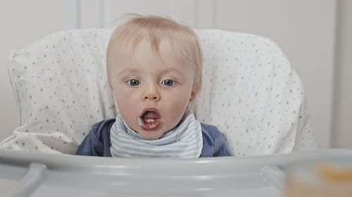 Baby Eating Food in High Chair