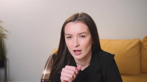 Woman Coughing In Her Fist At Home