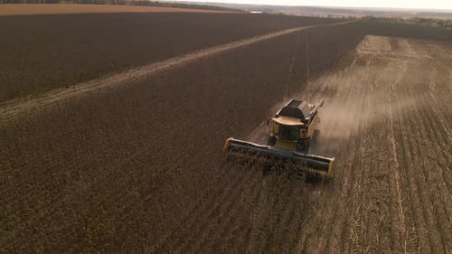 Zeitlupen-Luftaufnahme eines auf einem Feld arbeitenden Mähdreschers
