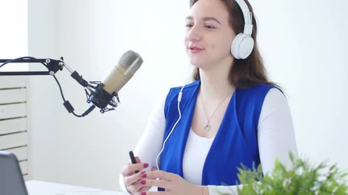 Cheerful Woman Broadcasting in a Studio with Microphone