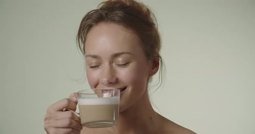 Woman Smiles While Drinking Latte Close-Up