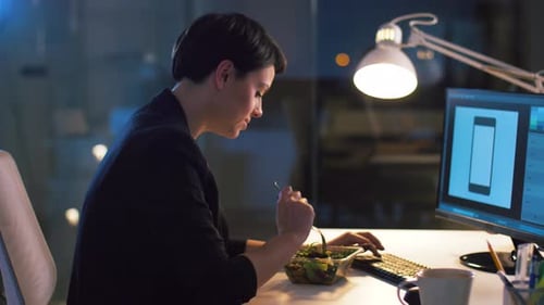 Businesswoman with Computer Eating at Night Office 33