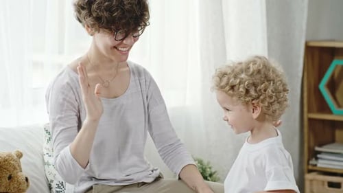 Mother Teaching Toddler Boy to High-Five