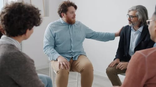 Chubby Guy Discussing Problems with People During Group Therapy in White Color Studio