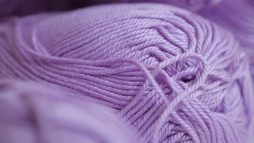 Yarn of wool wrapped in loose twist close-up 4K 2160p 30fps UltraHD panning footage - Pink knitting