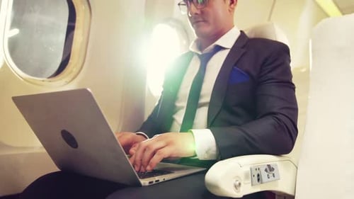 Man Working on Laptop Inside Airplane
