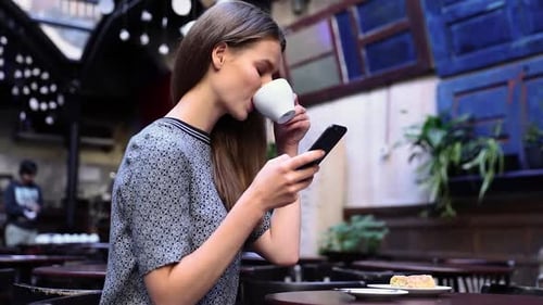 Woman With Phone At Cafe Drinking Coffee