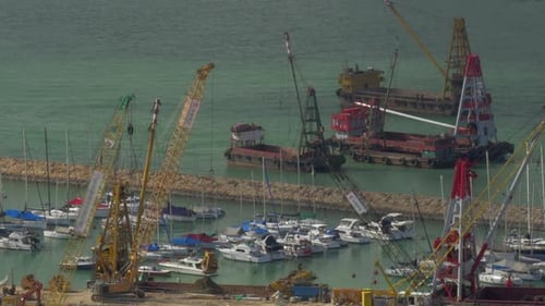 Luftaufnahme des Docks bei geschlossenem Lastkahn mit Sand durch Kran. Hongkong, China