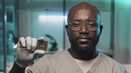Portrait of Black Engineer Holding Microprocessor in Lab