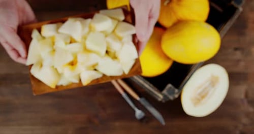 Des
mains masculines prennent une assiette avec des tranches de melon frais.
