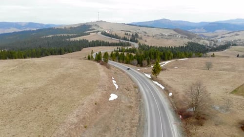Two Cars Are Moving on the Road in the Mountains